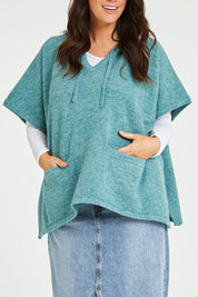 Model Laura wearing size M-L of the Keeping The Chill Out Poncho in colour Sea (Blue), from the front, cropped image