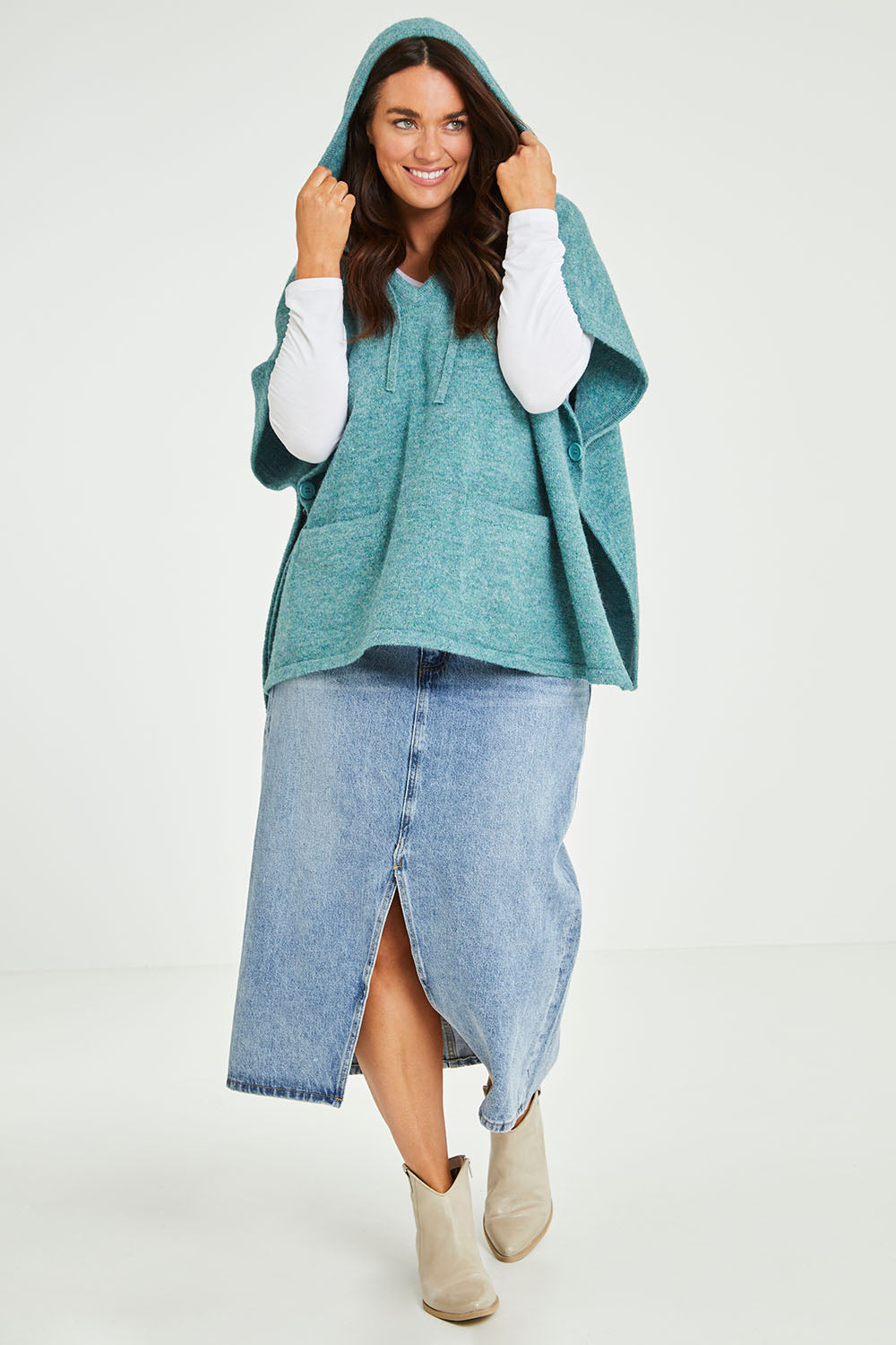 Model Laura wearing size M-L of the Keeping The Chill Out Poncho in colour Sea (Blue), from the front, showing the whole outfit