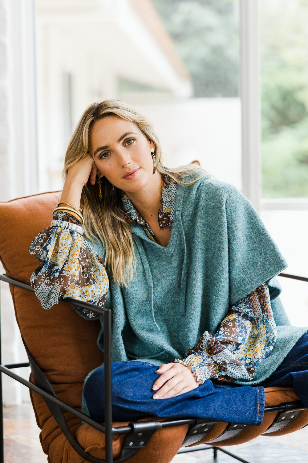 Model Tegan wearing size S-M of the Keeping The Chill Out Poncho in colour Sea (Blue), from the front, showing the whole outfit