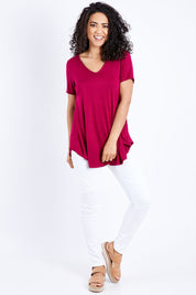 Model Pamela wearing size 10 of the Softly Swinging Bamboo Tee in colour Ruby (Red), from the front, showing the whole outfit