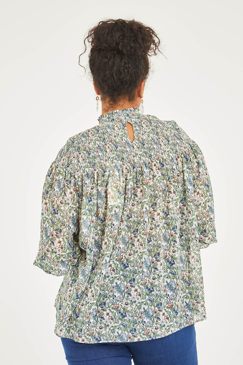 Model Noli wearing size 14 of the Romance In The Air Blouse in colour Fleur (Green), from the back