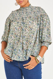 Model Noli wearing size 14 of the Romance In The Air Blouse in colour Fleur (Green), from the front, cropped image