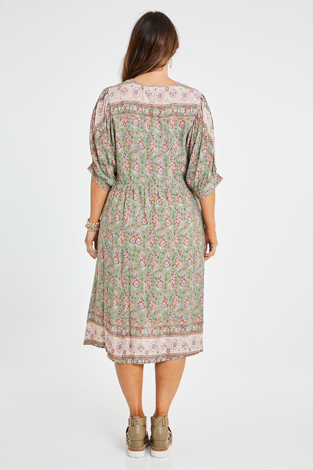 Model Laura wearing size 14 of the Sunshine And Flowers Smock Dress in colour Sagefleur (Green), from the back