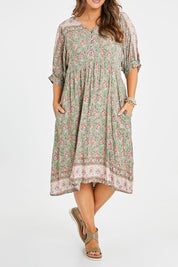 Model Laura wearing size 14 of the Sunshine And Flowers Smock Dress in colour Sagefleur (Green), from the front, cropped image
