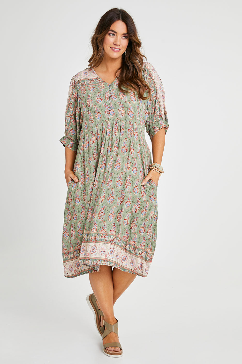 Model Laura wearing size 14 of the Sunshine And Flowers Smock Dress in colour Sagefleur (Green), from the front, showing the whole outfit