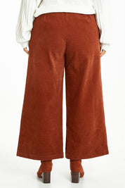 Model Laura wearing size 14 of the Feeling Good Wide Leg Cord Pants in colour Rust, from the back