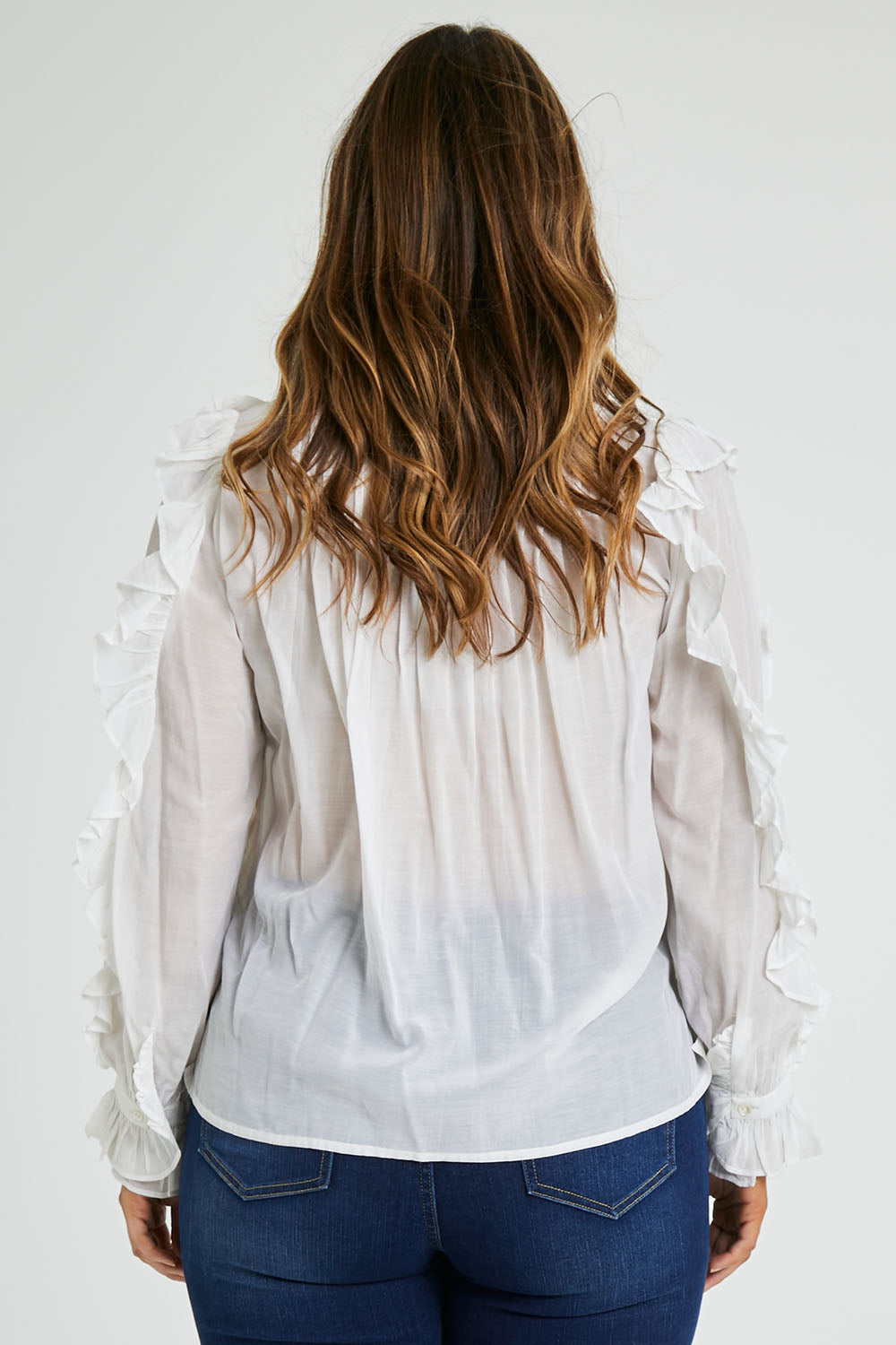 Model Laura wearing size 14 of the Ruffled Feathers Blouse in colour White (White), from the back