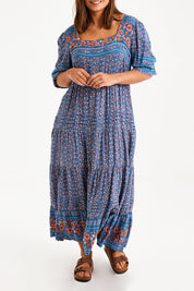 Model Monique wearing size 14 of the Paradise Found Maxi Dress in colour Denimfleur (Blue), from the front, cropped image