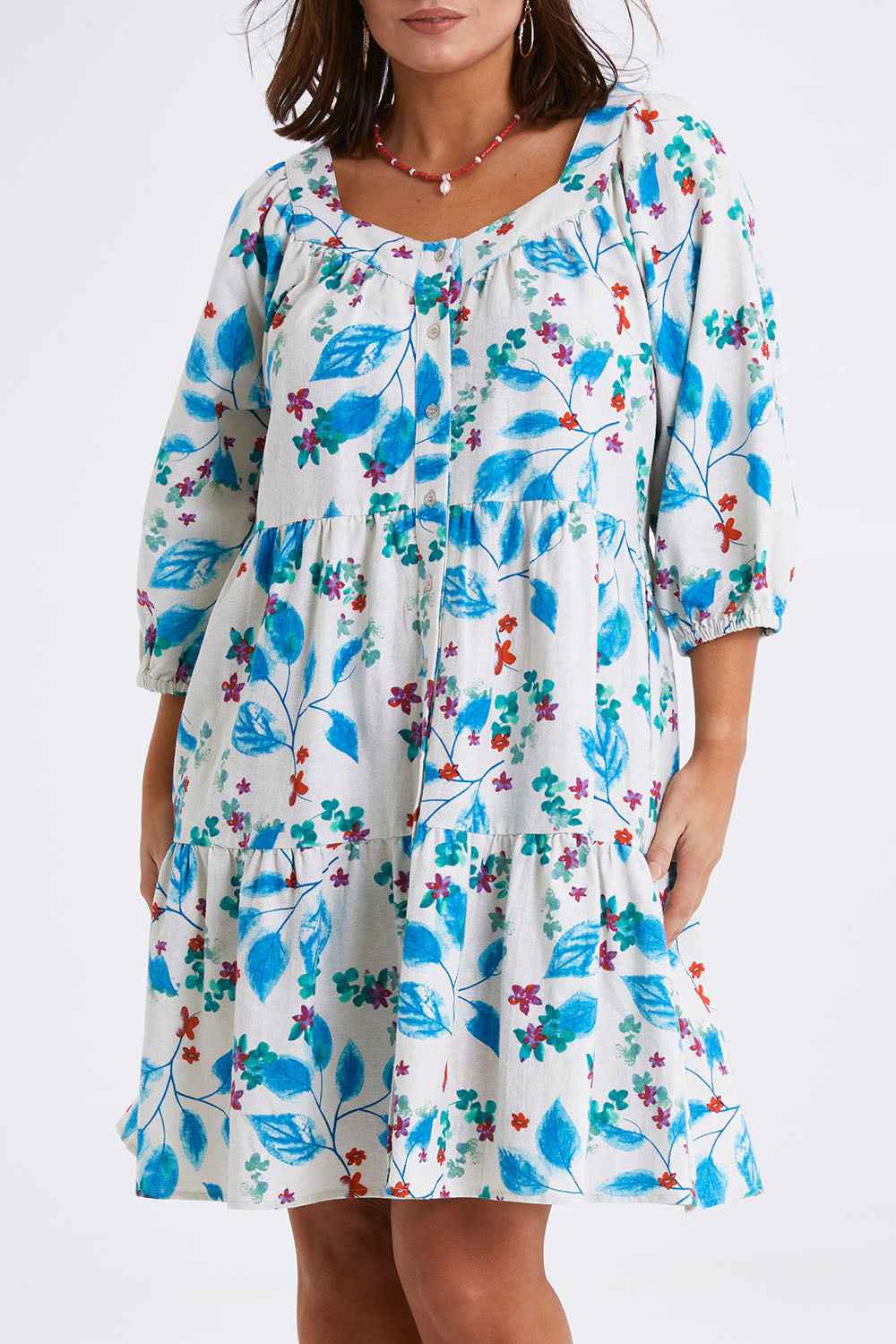 Model Monique wearing size 14 of the Chasing Blue Sky Cotton Dress in colour Blueleaf (Blue), from the front, cropped image