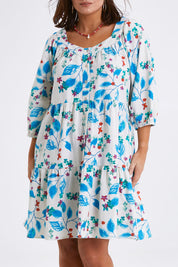 Model Monique wearing size 14 of the Chasing Blue Sky Cotton Dress in colour Blueleaf (Blue), from the front, cropped image