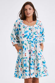 Model Monique wearing size 14 of the Chasing Blue Sky Cotton Dress in colour Blueleaf (Blue), from the front, cropped image
