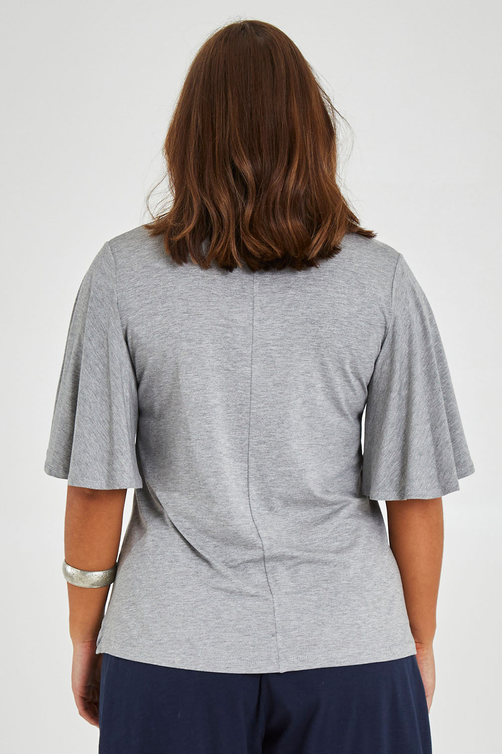 Model Monique wearing size 14 of the Flutter By Tee in colour Lightgrey (Grey), from the back