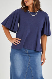 Model Monique wearing size 14 of the Flutter By Tee in colour Marldenim (Blue), from the front, cropped image