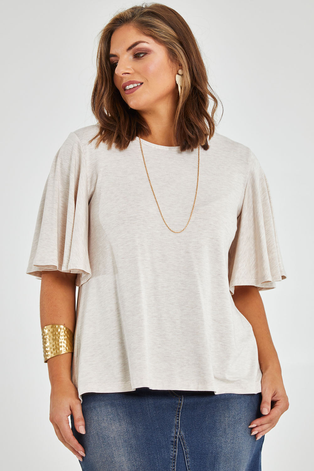 Model Monique wearing size 14 of the Flutter By Tee in colour Natural, from the front, cropped image