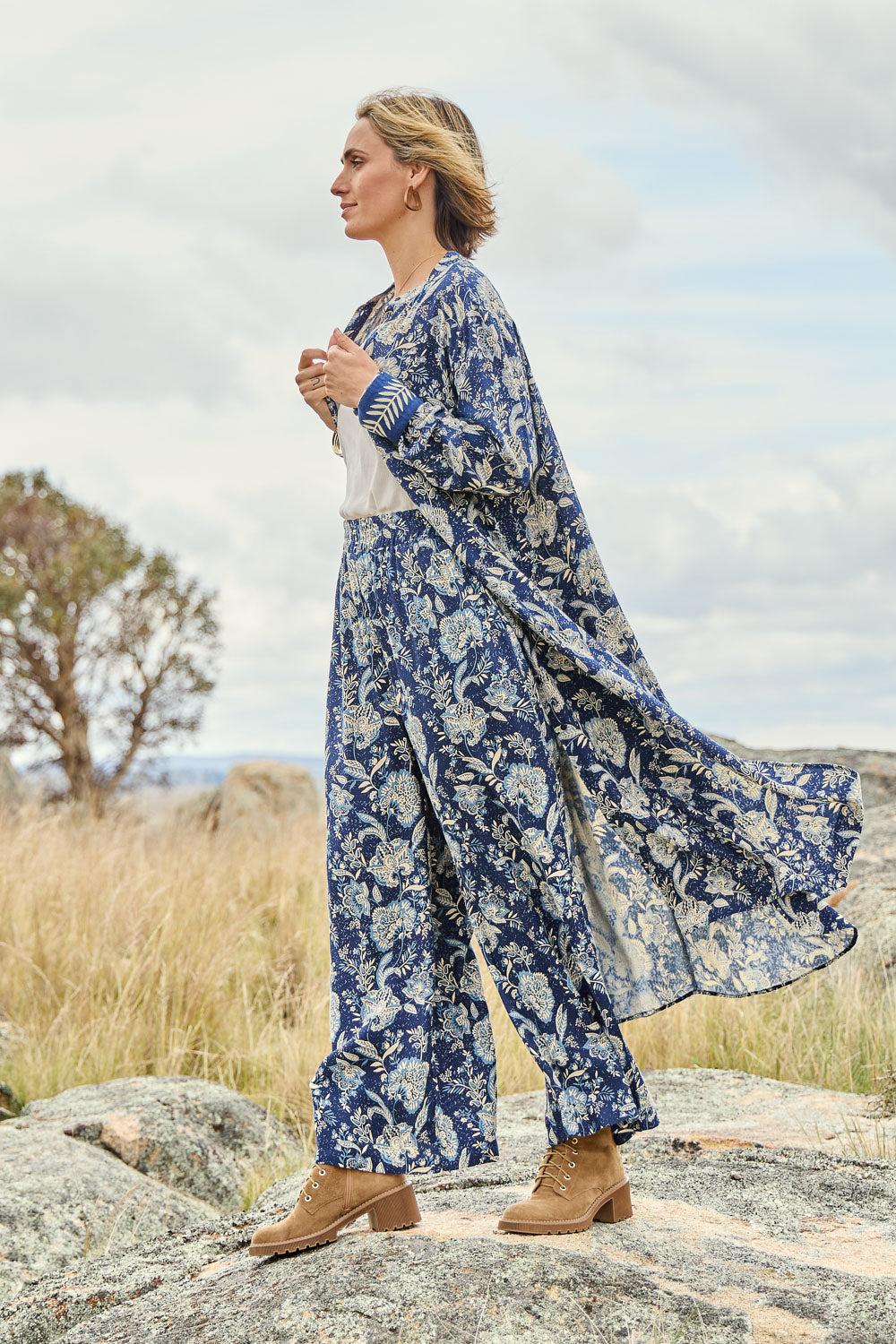 Model Tegan wearing size 10 of the Swept Away By You Duster Blouse in colour Bluefleur (Blue), from the front, showing the whole outfit