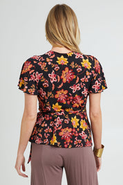 Model Grace wearing size 10 of the All For You Wrap Top in colour Blkfleur (Black), from the back