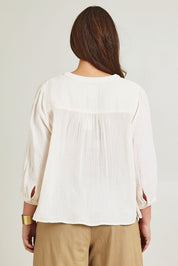 Model Jane wearing size 14 of the First Light Cotton Blouse in colour Milk (White), from the back