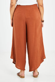 Model Sasha-Lee wearing size 16 of the Wrapped In You Cotton Pants in colour Cinnamon, from the back