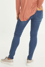 Model Cara wearing size 10 of the Wild Plains Stitched Jeggings in colour Denim (Blue), from the back