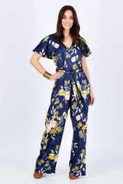 Model Georgia wearing size 10 of the Sunday Picnic Jumpsuit in colour NavyFluer (Blue), from the front, showing the whole outfit
