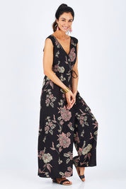 Model Gemma wearing size 10 of the Illusion Faux Wrap Jumpsuit in colour Blackfleur (Black), from the front, showing the whole outfit