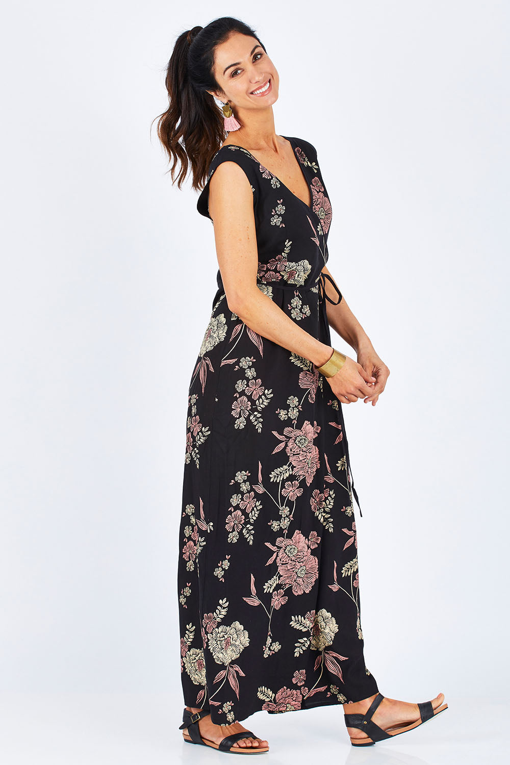 Model Gemma wearing size 10 of the Illusion Faux Wrap Jumpsuit in colour Blackfleur (Black), from the front, showing the whole outfit