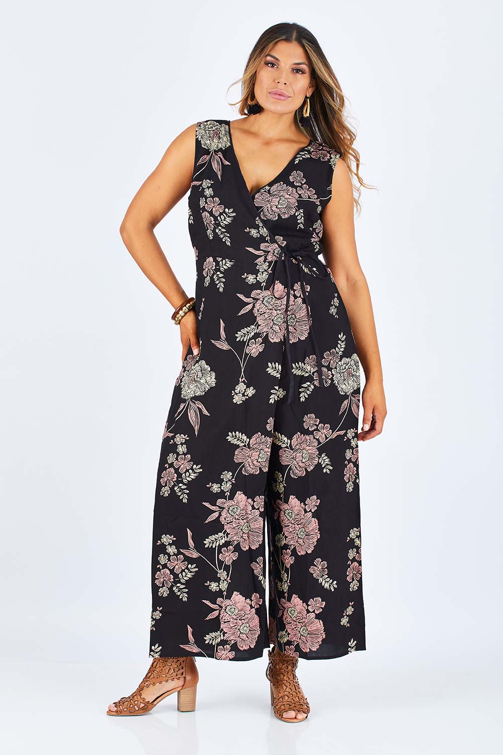 Model Palatina wearing size 14 of the Illusion Faux Wrap Jumpsuit in colour Blackfleur (Black), from the front, showing the whole outfit