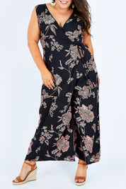 Model Stacey wearing size 16 of the Illusion Faux Wrap Jumpsuit in colour Blackfleur (Black), from the front, cropped image