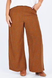 Model Stacey wearing size 14 of the Spotty About You Wide Leg Pants in colour Rust, from the front, cropped image
