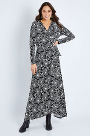 Model Elhana wearing size 10 of the Flowers In Winter Wrap Maxi Dress in colour Blkwhite (Black), from the front, showing the whole outfit