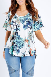 Model Laura wearing size 14 of the Free Falling Top in colour Birdfleur (Blue), from the front, cropped image
