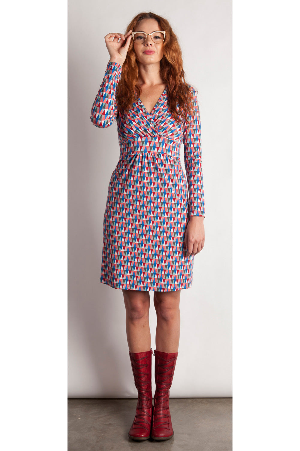 A model wearing the Lucia Dress in colour BlueFlags (Blue), from the front, showing the whole outfit