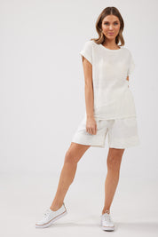 A model wearing the Percy Top in colour White (White), from the front, showing the whole outfit