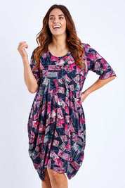 Model Laura wearing size 14 of the Rayon Bounce Dress in colour Print (Pink), from the front, cropped image