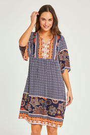 Model Elhana wearing size 10 of the Sun Dress in colour Navyprint (Blue), from the front, cropped image