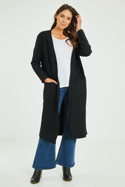 Model Madeline wearing size S-M of the Relaxed Rib Cardigan in colour Black (Black), from the front, showing the whole outfit