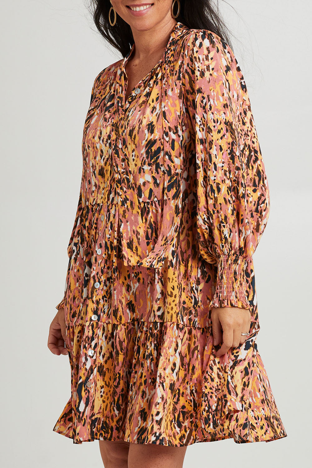 Model Katie wearing size S of the Mayan Dress in colour Ochre, from the front, cropped image