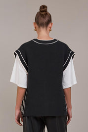 A model wearing the Avino Knit Vest in colour Black (Black), from the back