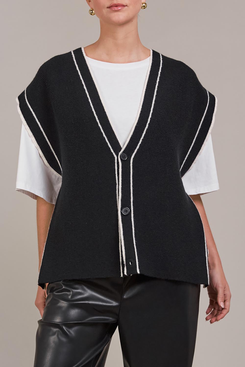 A model wearing the Avino Knit Vest in colour Black (Black), from the front, cropped image