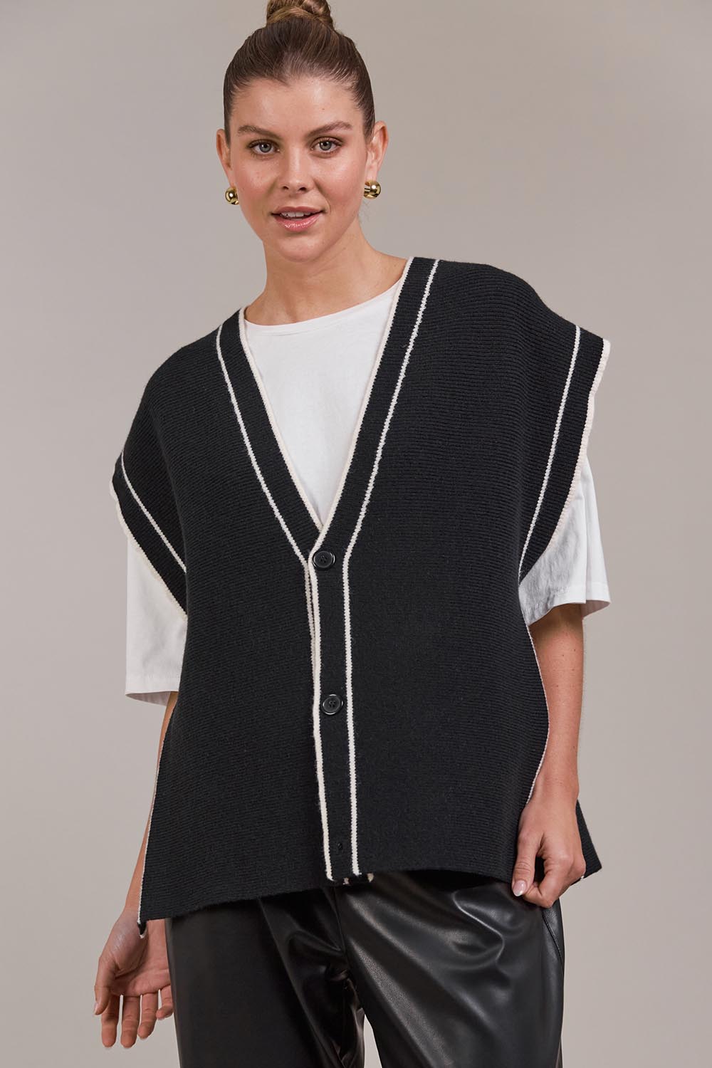 A model wearing the Avino Knit Vest in colour Black (Black), from the front, cropped image