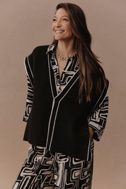 A model wearing the Avino Knit Vest in colour Black (Black), from the front, showing the whole outfit