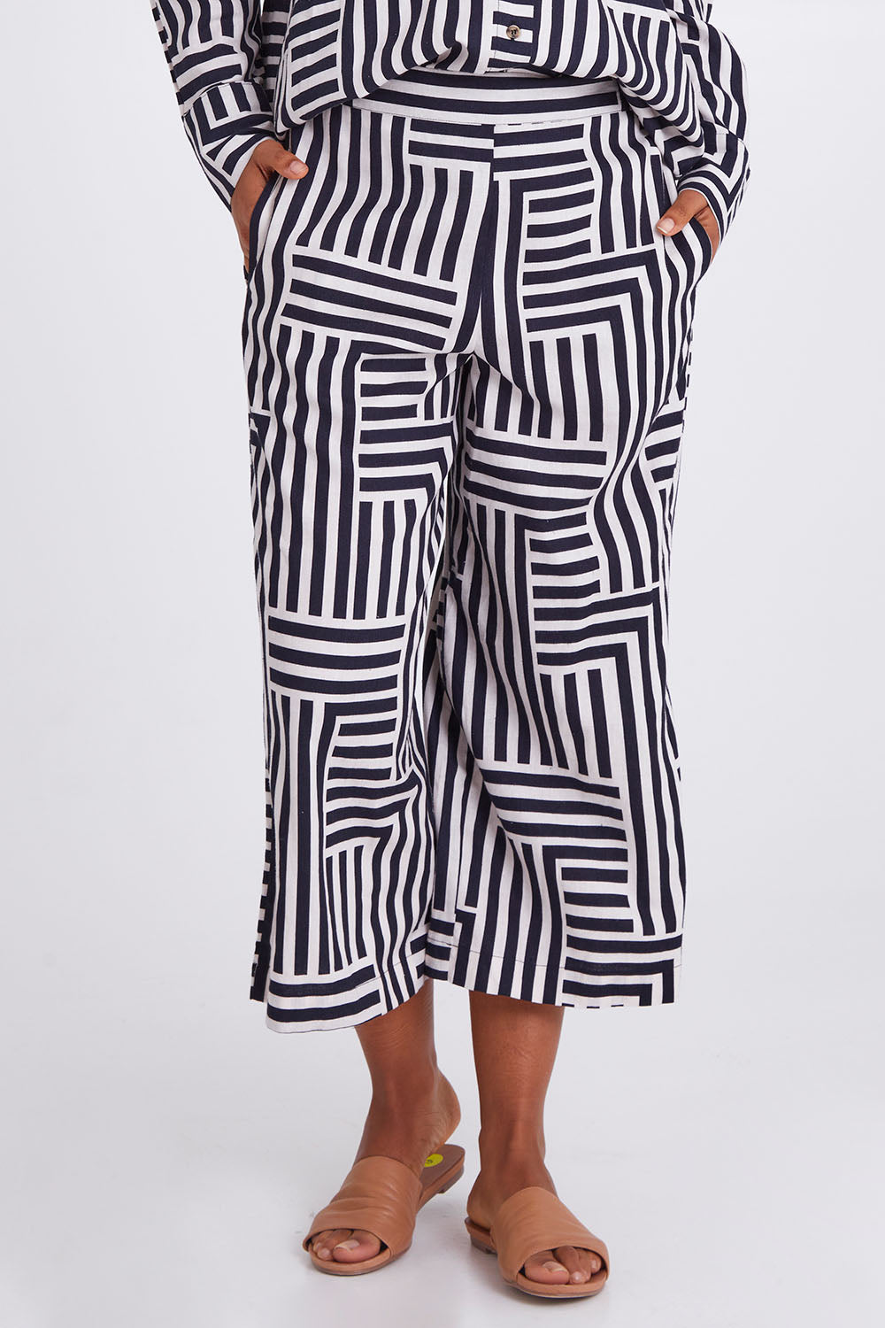 Model Olivia wearing size 10 of the Bauhaus Pant in colour Navyoat (Blue), from the front, cropped image