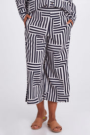 Model Olivia wearing size 10 of the Bauhaus Pant in colour Navyoat (Blue), from the front, cropped image