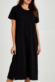 Model Madeline wearing size 10 of the Fundamental Adira Dress in colour Black (Black), from the front, cropped image