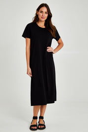 Model Madeline wearing size 10 of the Fundamental Adira Dress in colour Black (Black), from the front, showing the whole outfit