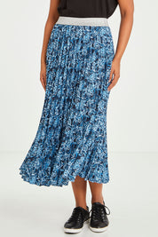 Model Olivia wearing size 10 of the Tilli Pleated Skirt in colour Indiflower (Blue), from the front, cropped image