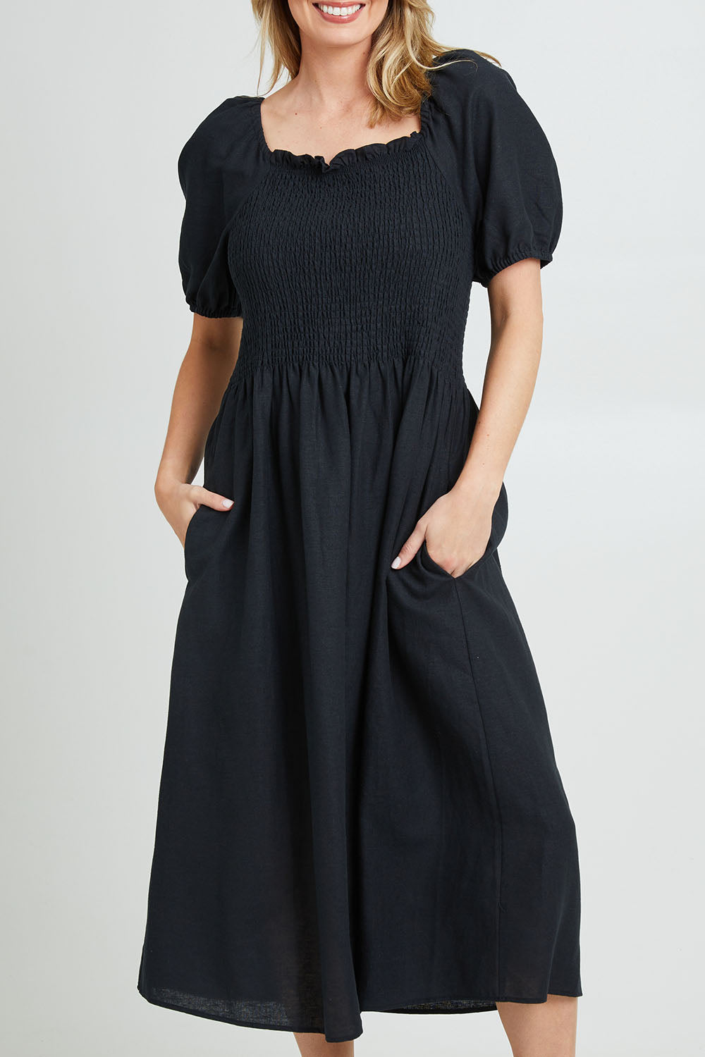 Model Grace wearing size 10 of the Ingrid Shoulder Dress in colour Coal (Black), from the front, cropped image