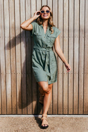 A model wearing the Harlow Dress in colour Khaki (Green), from the front, showing the whole outfit