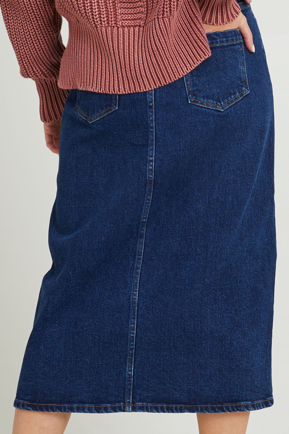 Model Grace wearing size 10 of the Scout Midi Skirt in colour Indidenim (Blue), from the back