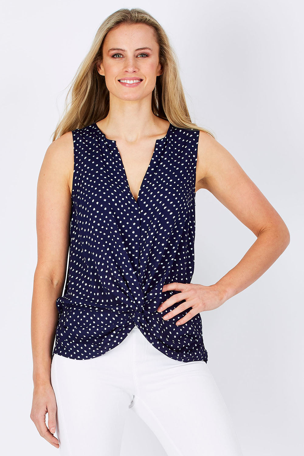 Model Maddy wearing size 10 of the Martinike Sleeveless Top in colour NavyPolka (Blue), from the front, cropped image